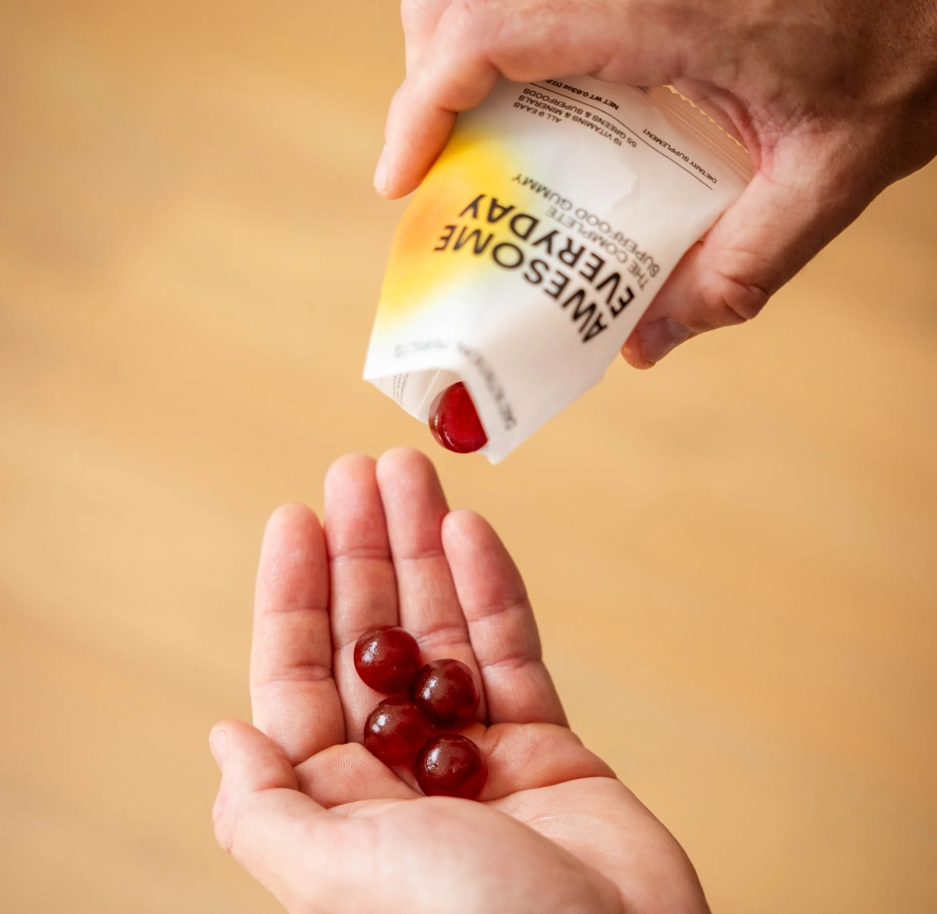 Awesome Everyday gummies being poured into a hand from a daily nutrition packet.